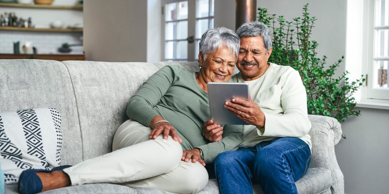 Older couple looking at ipad on couch