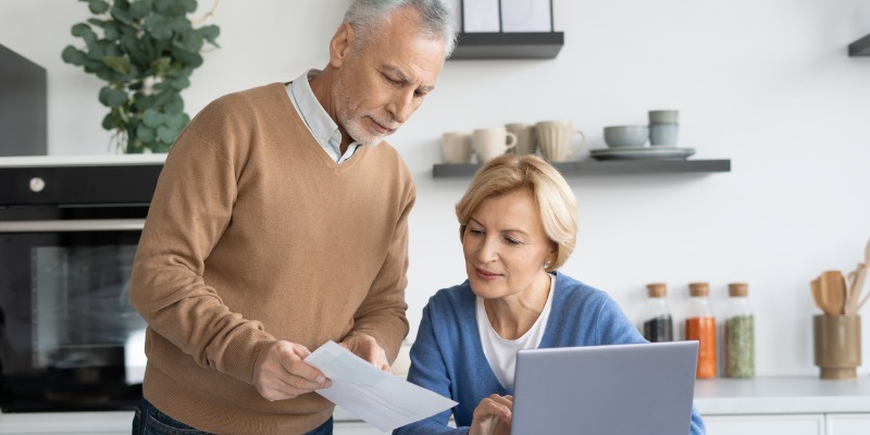 Older couple looking at document in kitchen - Are You Worried About Inflation? Here's How a Reverse Mortgage Can Help 